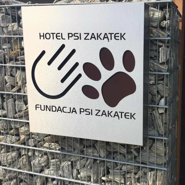 Kaseton typu dibond z logo psi zakątek na ogrodzeniu